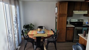 A dining area with a round table, chairs, and a potted plant. - ​Work Crew Special: Monthly Rates Full Kitchen & Laundry (Douglas)