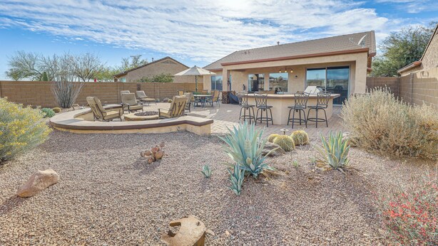Un jardin avec un espace patio, des sièges d’extérieur et un barbecue.