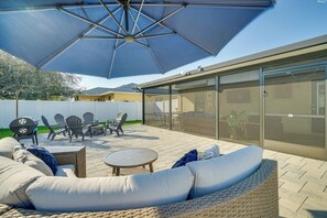 An outdoor patio with a covered seating area, including a sofa and chairs, and a grill. - 7 Mi to River District: Cape Coral Home w/ Lanai (Cape Coral)