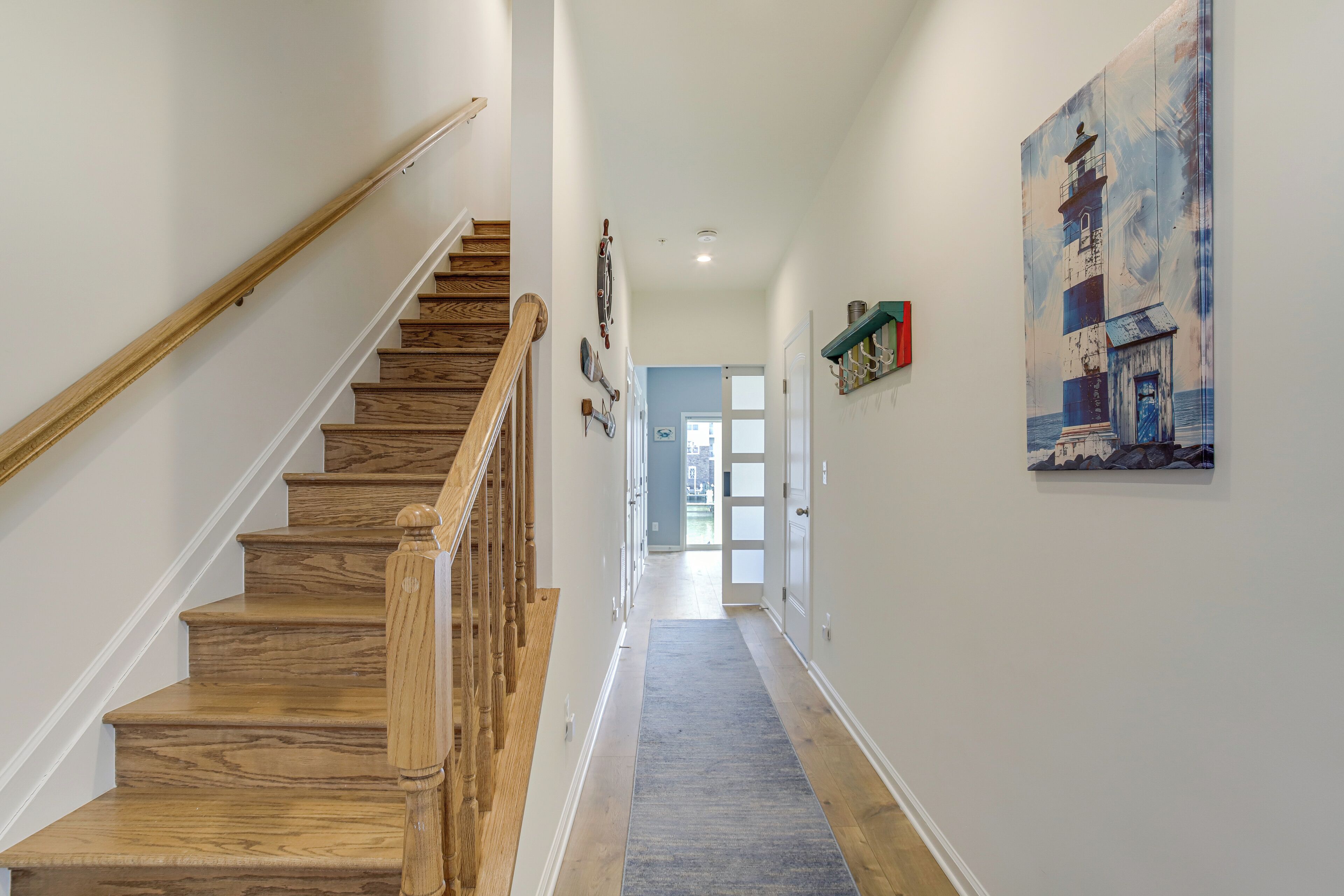 A wooden staircase leading to a landing with a blue carpet.