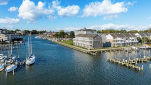 A marina with boats docked, a large building with a white facade, and a clear blue sky. - Walk to Dtwn: Waterfront Eastern Shore Townhome! (Cambridge)
