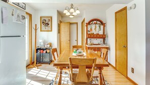 A dining area with a wooden table and chairs, a chandelier, and a kitchen in the background. - 'red Barn Getaway' Chillicothe Countryside Home (Chillicothe)