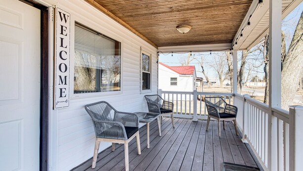 A covered porch with a 'WELCOME' sign, wooden chairs, and a small table. - Mins to Local Attractions: Pet Friendly w/ Yard! (Casey)