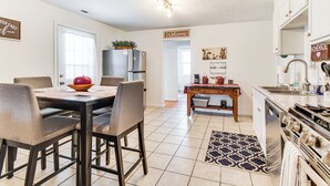 A modern kitchen with a dining area, stainless steel appliances, and a welcome sign. - Mins to Local Attractions: Pet Friendly w/ Yard! (Casey)