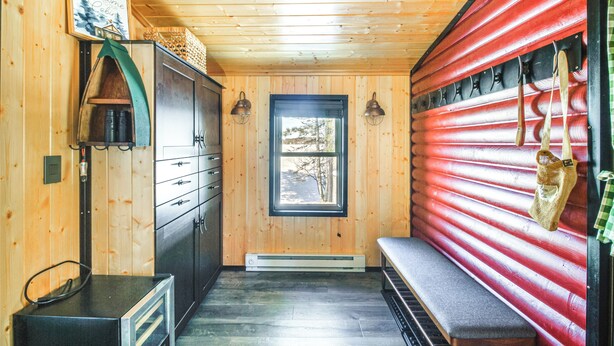 A cabin interior with wooden walls, a bench, a window, and a door. - Lakefront Cabin on Lake Vermilion w/ Large Dock (Tower)