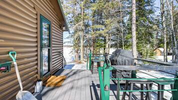 Enjoy al fresco dining on the cabin's outdoor deck, equipped with a table, chairs, and barbecue grill.