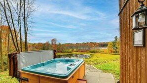 A wooden hot tub with a view of a pond and autumn trees. - Golf, Fish & Ski: Retreat w/ Game Room in Thompson (Thompson)