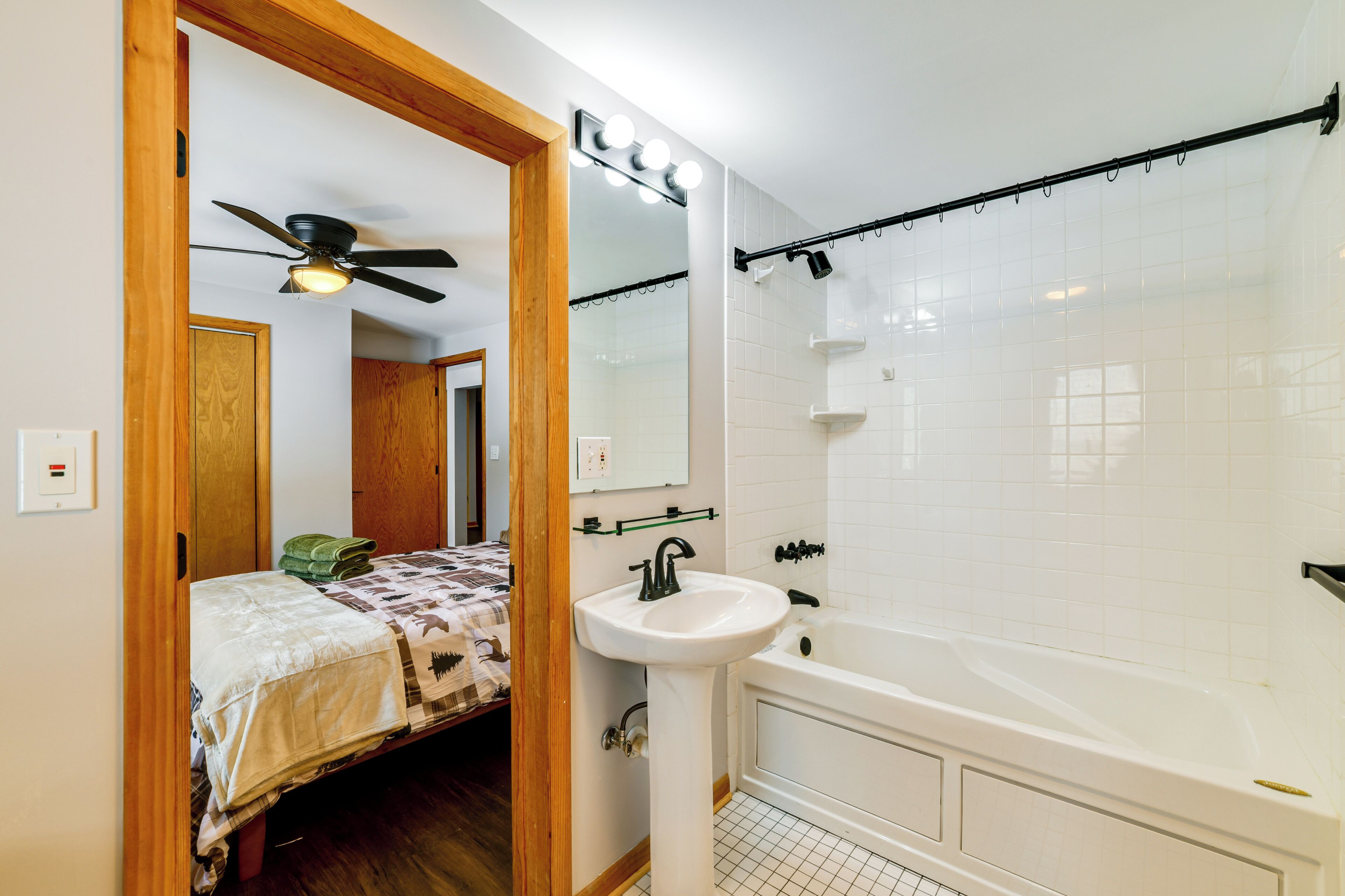 Une salle de bain avec un lavabo blanc, une baignoire et un rideau de douche.