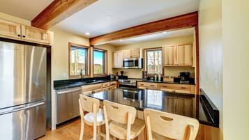 A modern kitchen with wooden cabinets, stainless steel appliances, and a central island with bar stools.
