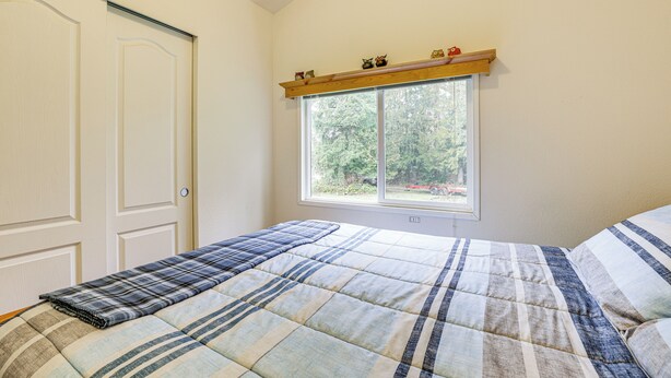 Ein Schlafzimmer mit Bett, Fenster und Tür.