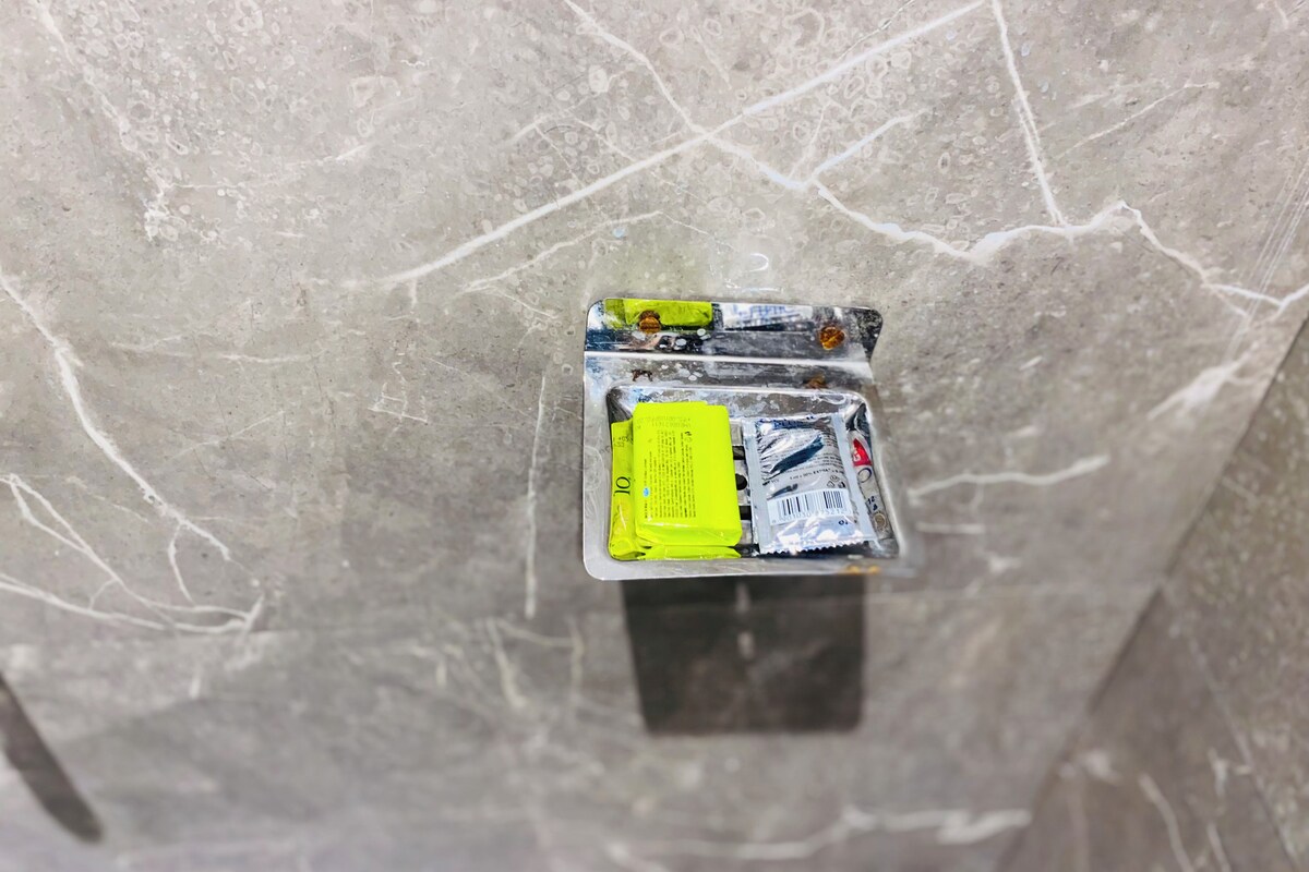 Een marmeren muur met een klein, rechthoekig object met een batterij en een kabel.
