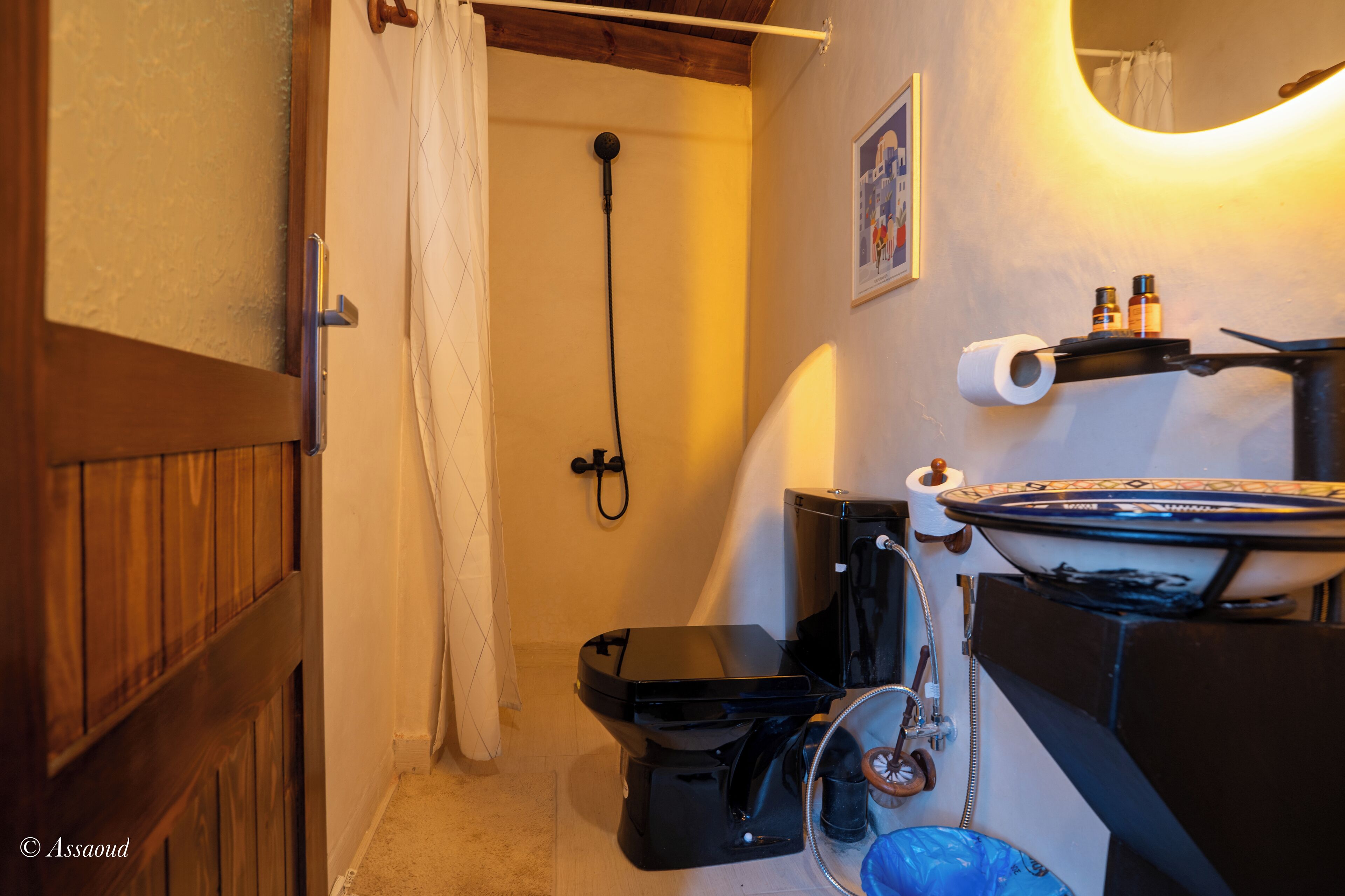 Een badkamer met douche, toilet en wastafel.
