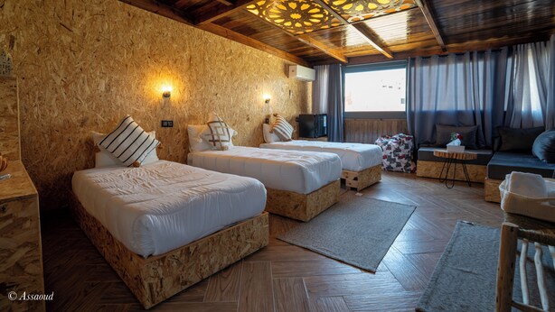 A room with two wooden beds, a sofa, and a television. - DAR BLANCA (Chefchaouen)