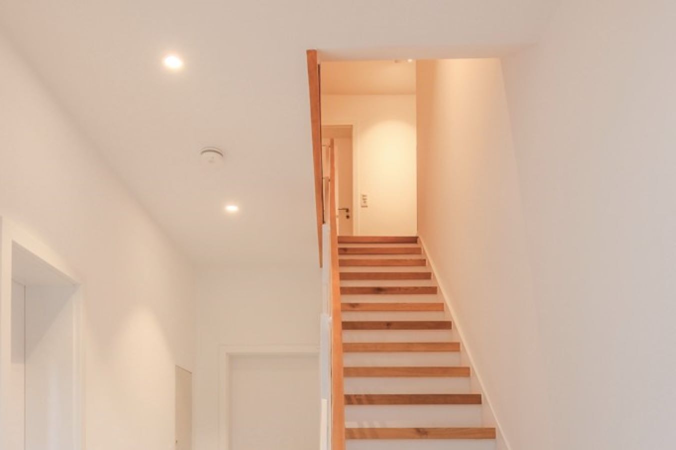 Una escalera de madera con peldaños que conducen a una puerta en la parte superior.