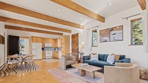 A spacious living area with a wooden ceiling, a sofa, a coffee table, and a dining table with chairs. - Southwestern Casita with A/C, Sopris Views & Fenced Yard Near Aspen & Carbondale (Carbondale)