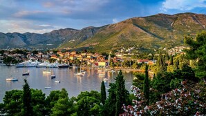 A coastal town with a marina, boats, and mountains in the background.
