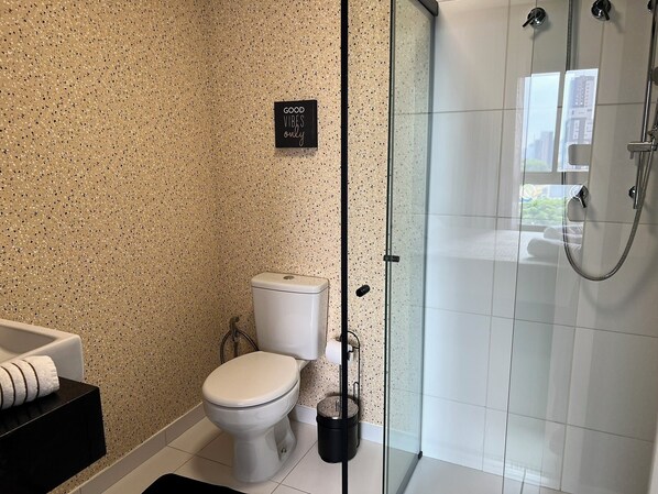 A bathroom with a toilet, a shower, and a sign that says "GOOD VIBES only".