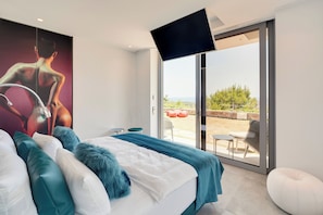 Une chambre à coucher avec un lit, une grande fenêtre et une vue sur l’extérieur.