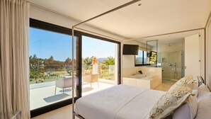 Ein modernes Schlafzimmer mit einem großen Bett, einem Balkon mit Stuhl, einem Badezimmer mit Badewanne und Blick ins Freie.