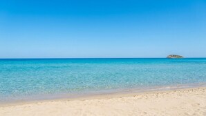 Ein Strand mit klarem türkisblauem Wasser und einem Sandstrand.