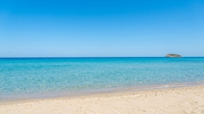 Ein Strand mit klarem türkisblauem Wasser und einem Sandstrand.