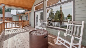 A wooden deck with a covered area, a fire pit, and white chairs. - Mountain Retreat With Hot Tub, Game Room And Yard 3 Bedroom Home (Cle Elum)