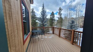 A wooden deck with a table and chairs, overlooking a snowy landscape with trees. - 3br Red Hawk Townhome - Gondola Access 3 Bedroom Townhouse (Keystone)