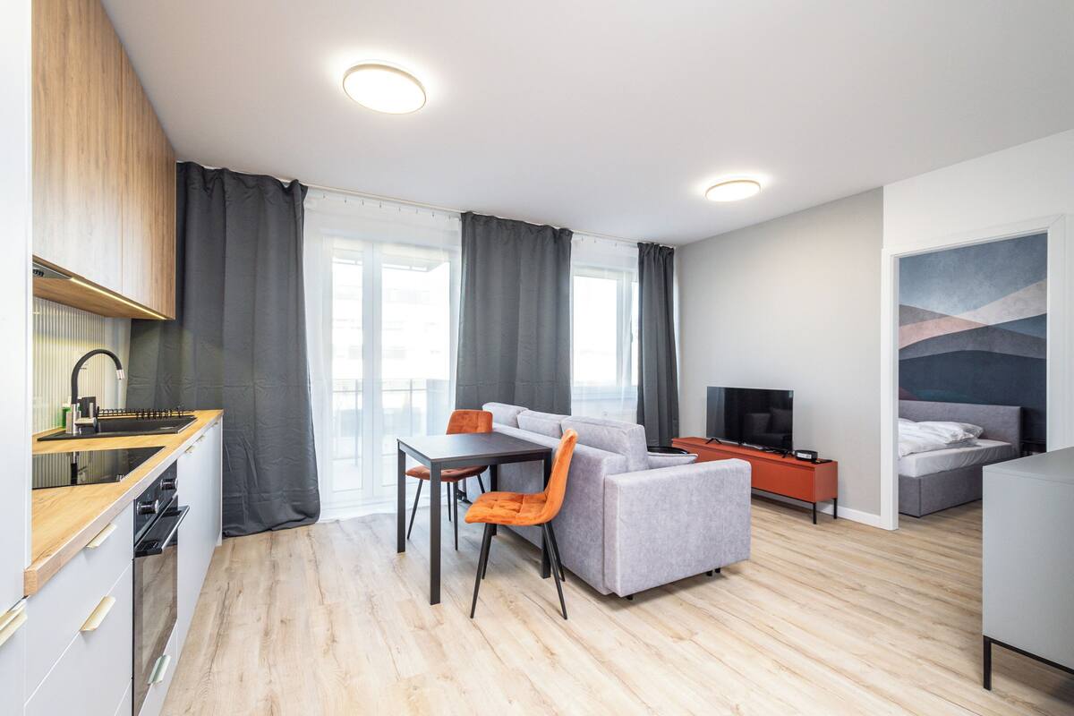 Un apartamento moderno con cocina, comedor y sala de estar. Cuenta con un sofá, televisión y cama.