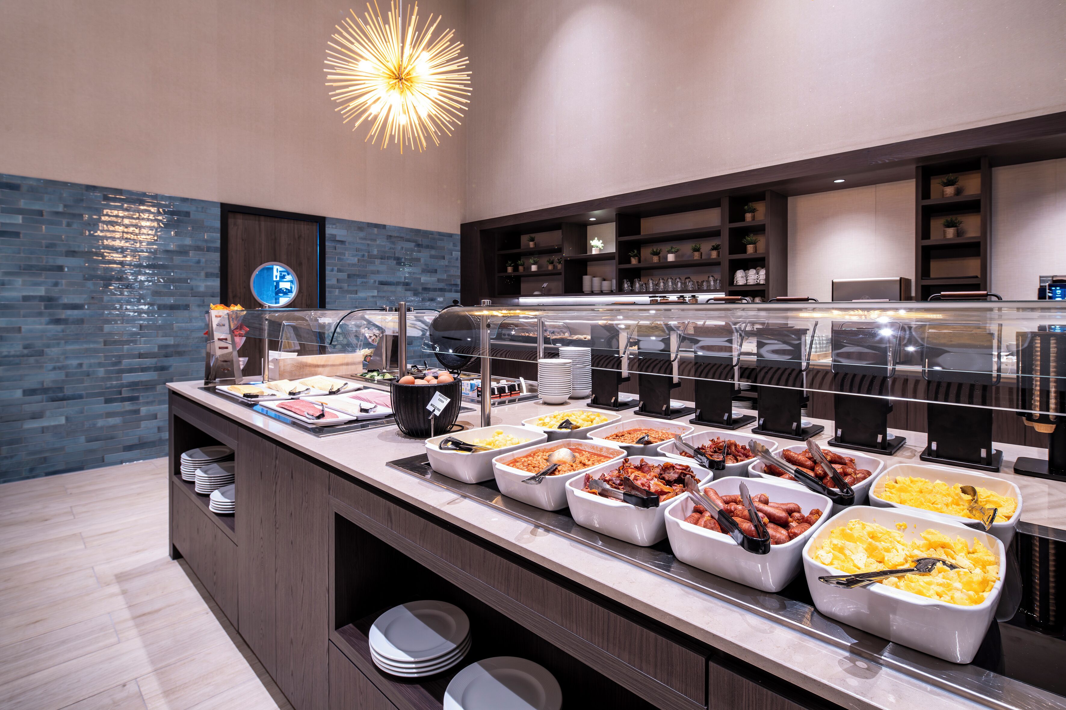 Un buffet garni de divers plats, un miroir et un luminaire décoratif.