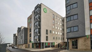 Ett hotell med flera våningar, med en tydlig grön logotyp på fasaden, vilket visar att det är ett iQ-hotell.
