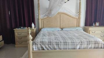Ein Schlafzimmer mit einem hölzernen Bett, zwei Nachttischen, einem Wandleuchter und einem Beistelltisch.