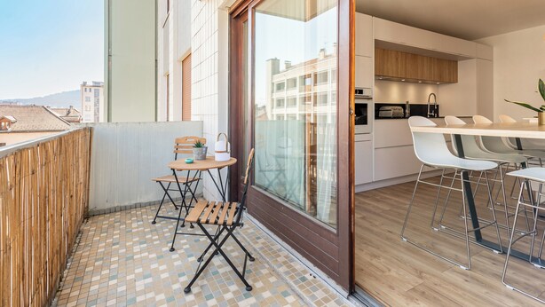 A modern apartment with a balcony, a small dining area, and a kitchen. - La Quinta - Appartement en Centre ville (Annecy)