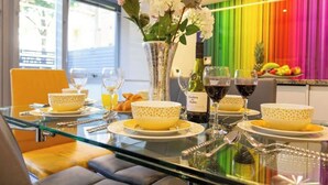 A breakfast table set with bowls, wine glasses, and a vase of flowers.