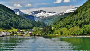 A lake surrounded by forested hills with a small village and houses. - Eidsdal Hotel & Restaurant As (Eidsdal)