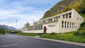 A two-story building with a sign reading 'HIMSDAL 888' and a flag in front. - Eidsdal Hotel & Restaurant As (Eidsdal)