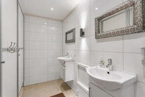 Enjoy a refreshing bathroom experience with a pedestal sink, separate vanity, and large mirror.