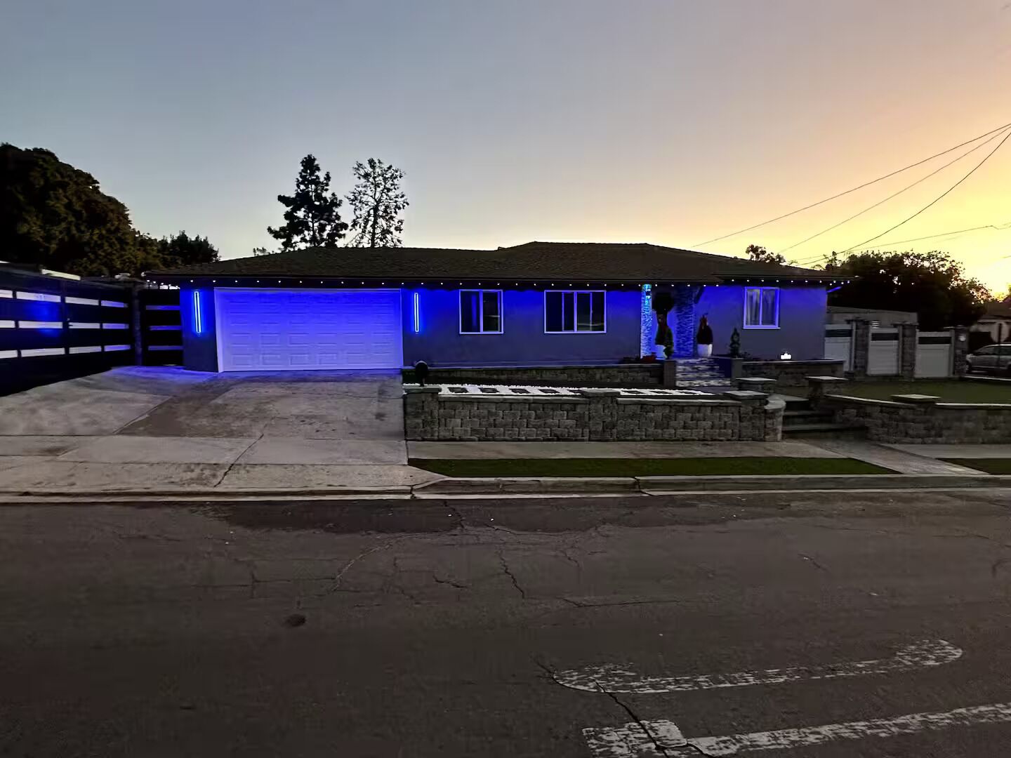 A residential house with a garage, a driveway, and a small front yard with a stone planter.