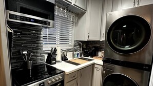 A modern kitchen with stainless steel appliances, including a stove, oven, and double sink.