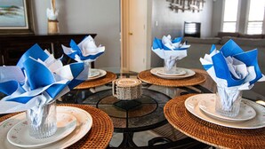 A dining area with round tables set for a meal, featuring blue and white napkin arrangements. - Coastal Coral Paradise with Heated Pool (Cape Coral)