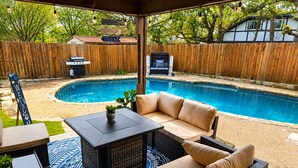 A covered patio with a pool, outdoor furniture, and a barbecue grill. - Diamond Waters near DFW & Stadium with Private Pool (Fort Worth)
