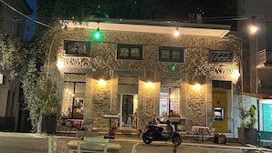 Edifici de pedra amb diverses finestres i una moto aparcada al davant.