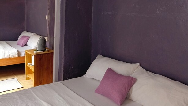 A bedroom with a bed, a nightstand, a mirror, and a painting on the wall. - Wrech House 1989 - Sagana (Sagana)