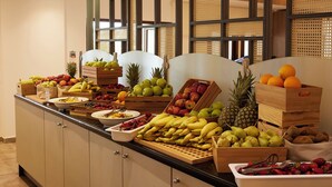 A buffet with various fruits and vegetables displayed in wooden crates and bowls. - Atlantica Marmari Beach (Kos)