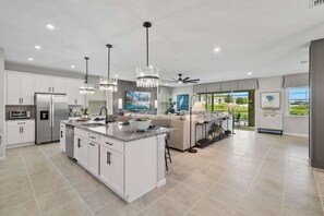 A modern kitchen with a central island, built-in appliances, and pendant lighting.
