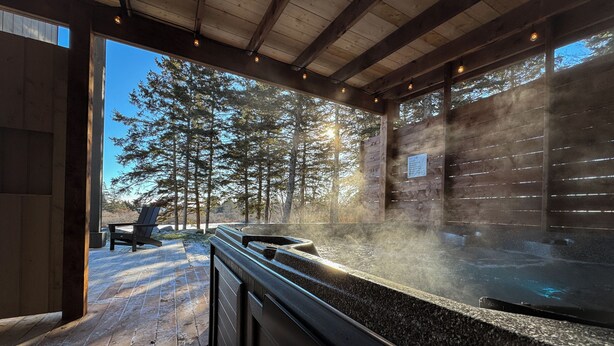 Zona de sauna con cubierta de madera, banco y ducha de vapor.