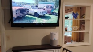Ein Flachbildfernseher ist über einem Kamin angebracht, in dem ein Feuer brennt.