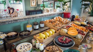 Un bufé de desayuno con diversas frutas, pasteles y salsas.