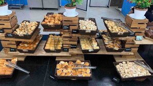 A buffet with various baked goods and pastries displayed on wooden stands. - Hotel Riviera Caldas Novas, in the city center. Pet friendly, (Turista 1 Caldas Novas)