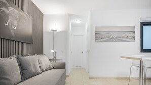 Een moderne hotelkamer met een bank, een bureau, een lamp en een wanddecoratie van een olifant.
