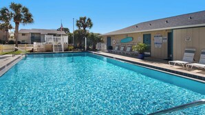 A clear blue pool with a ladder, lounge chairs, and palm trees. - Chateau La Mer II 902 - Pirates Mermaid (Destin)